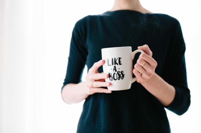 Entrepreneurial woman holding a mug that says "Like a Boss"