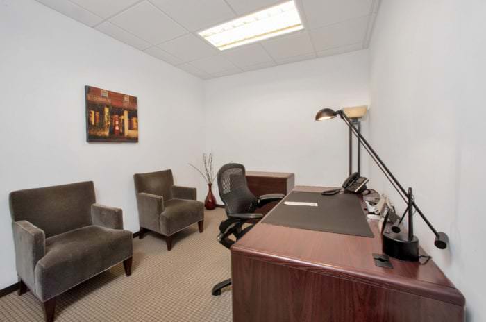 Personal office with a desk and several comfortable chairs for guests.