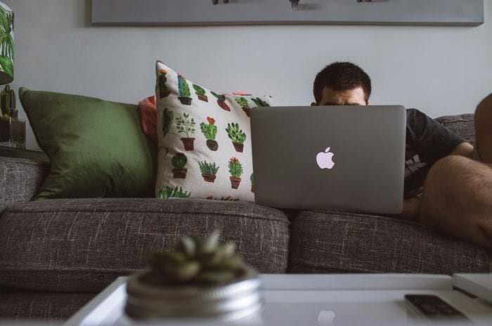 Man comfortably working from home on the couch